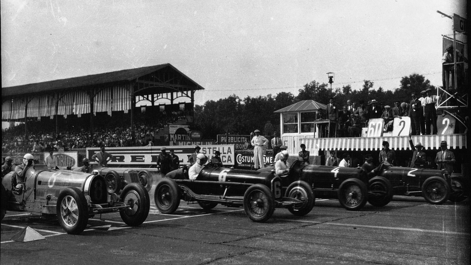 1932 Italia GP på Monza. Varzi i sin Bugatti, med Alfaer fra fabrikkslaget og Scuderia Ferrari ved siden av, i form av Caracciola, Brivio og Minozzi.