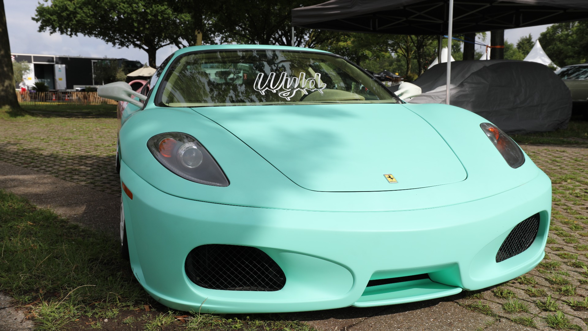 Rett forfra ser man en senket Ferrari med pastellgrønn farge.