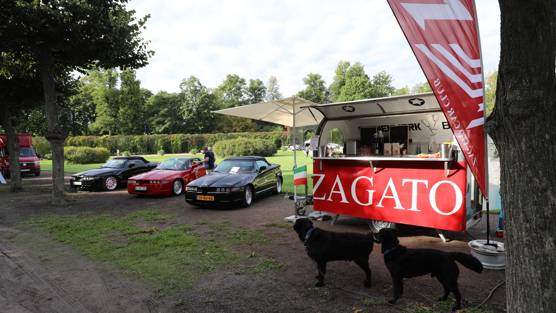 Klubbstanden til den tyske Zagato-klubben med et par firbeinte kamerater som beundrer Alfa-skjønnhetene. 