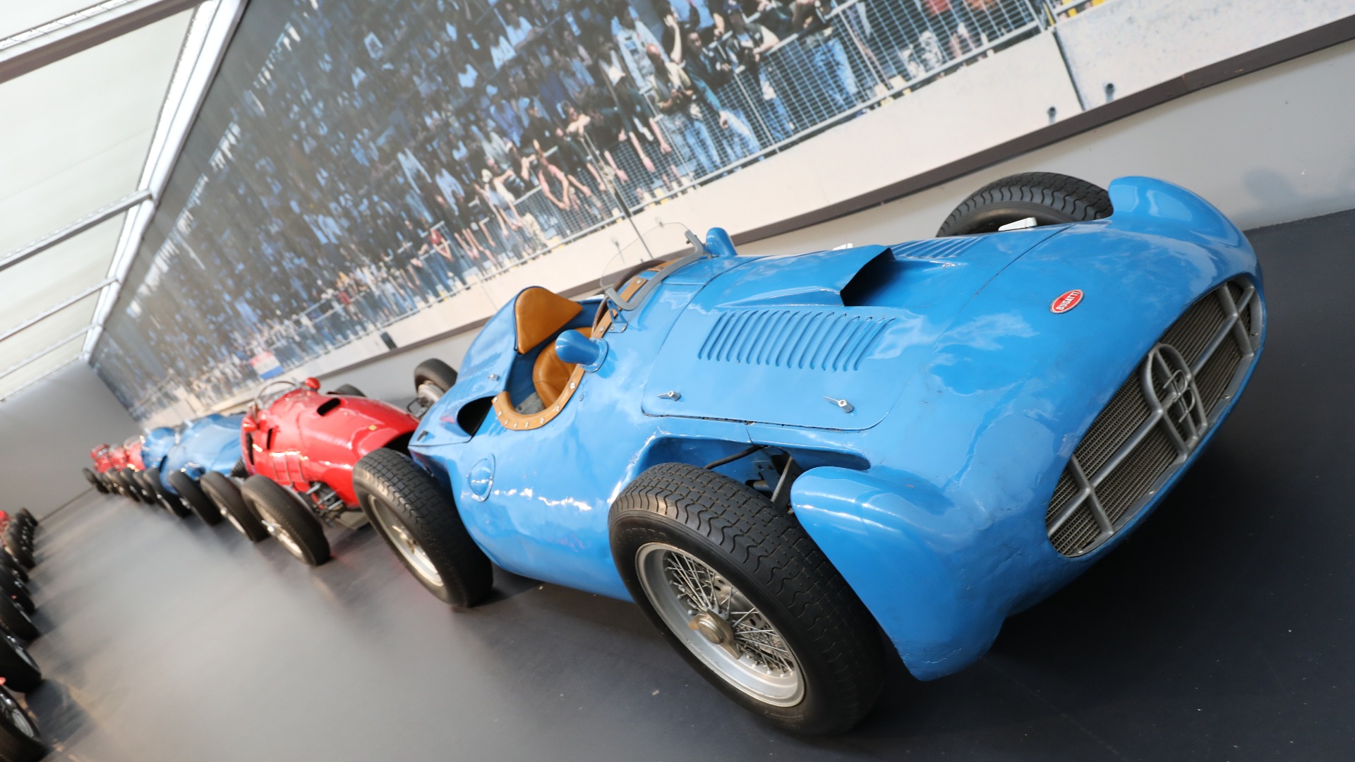 Mengder av 50-talls Formel 1 biler, med en Bugatti Type 251 i forgrunnen. Den ble svanesangen for Bugatti i racing. Ingeniør Gioacchino Colombo kom opp med en nyskapende bil hvor 2,5-liters rekkeåtteren var plassert på tvers rett bak føreren. Men mye problemer gjorde at bilen bare kjørte ett Formel 1 løp – 1956 Frankrike GP hvor bilen varte 18 runder. 