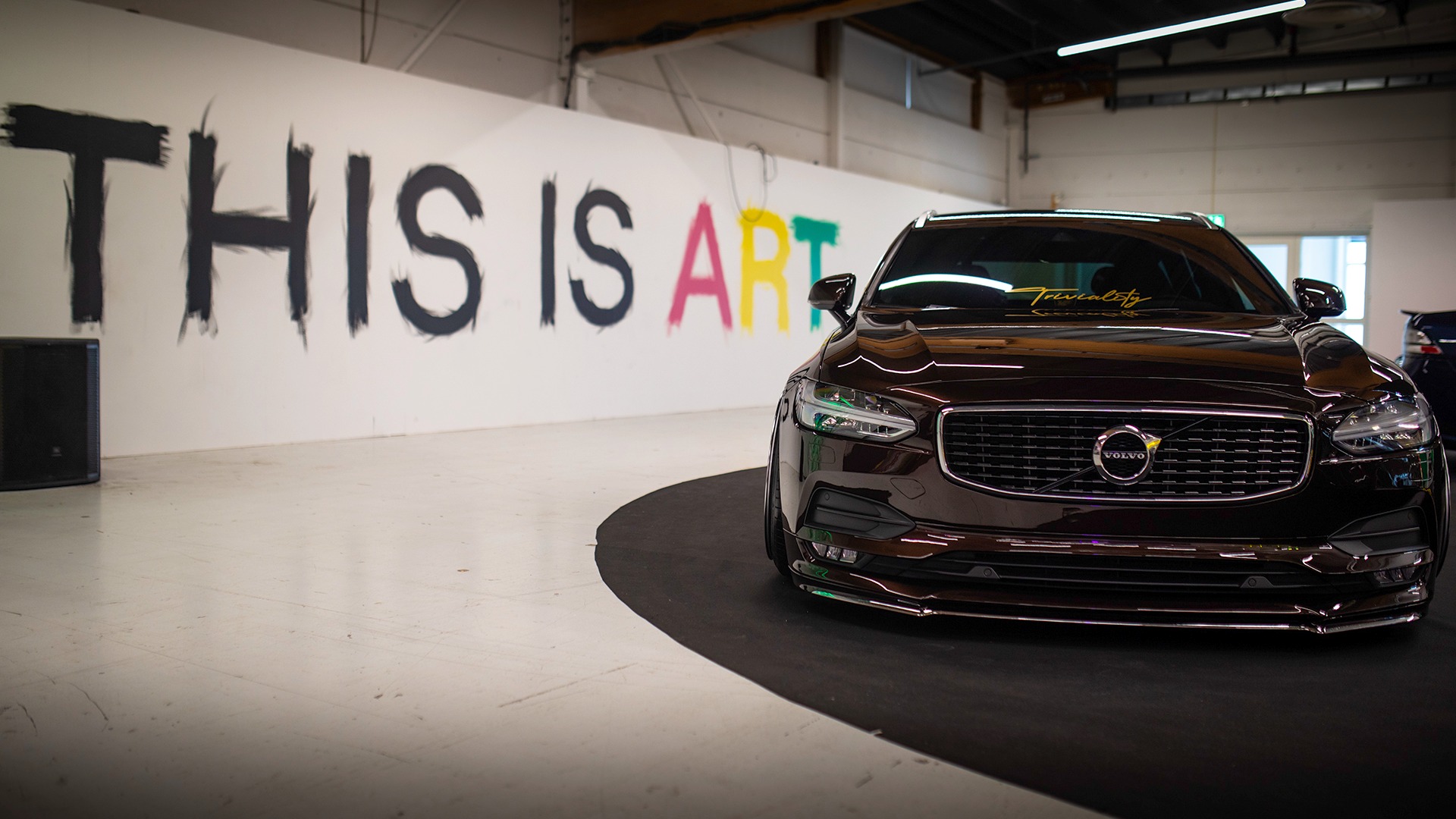 Veggene og gulvet var fylt med contemporary art, med gromme biler spredt rundt. Her en Volvo V90 med et definitivt budskap på veggen bak.