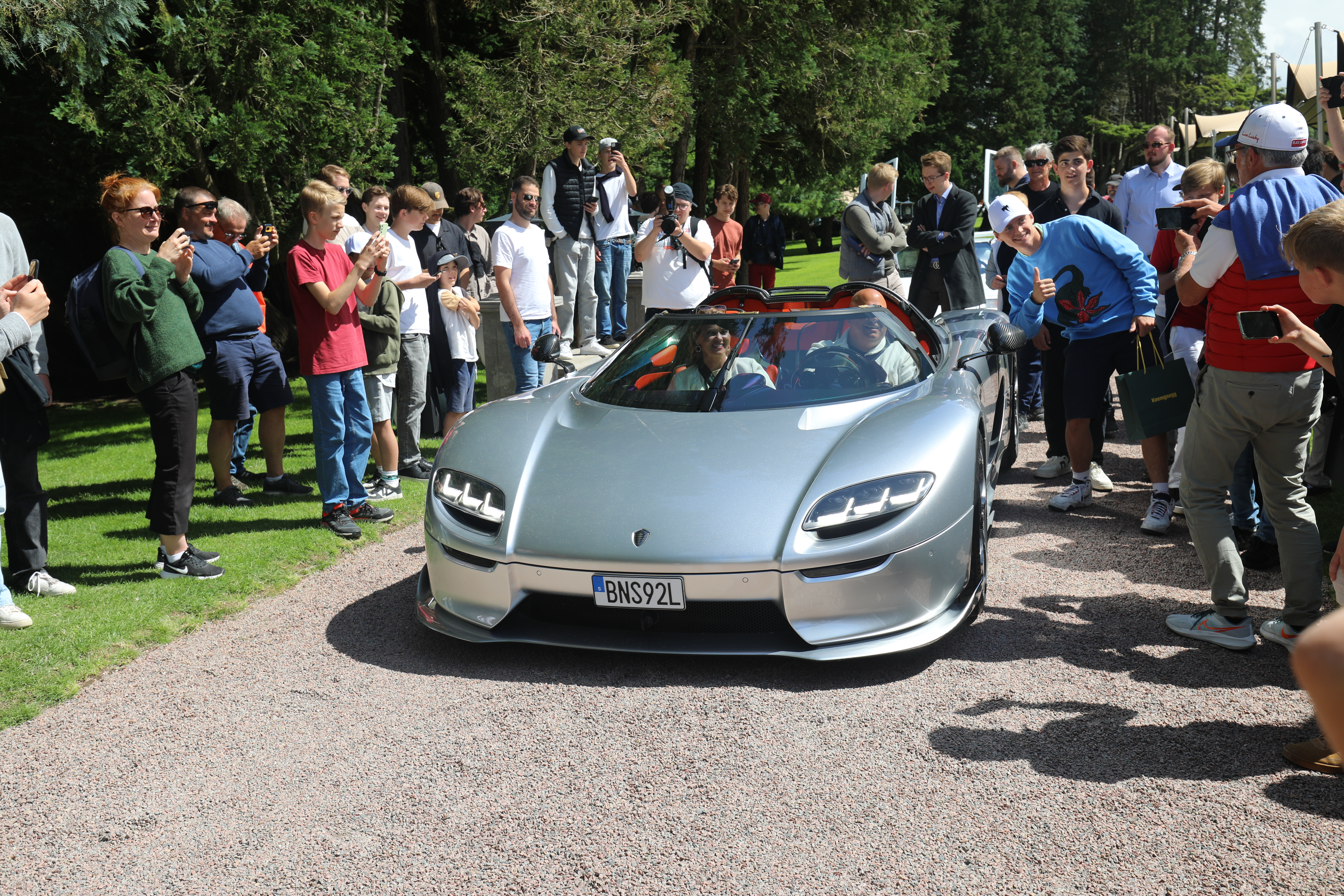 Christian von Koenigsegg ankommer, og da flokker de yngre entusiastene til. 