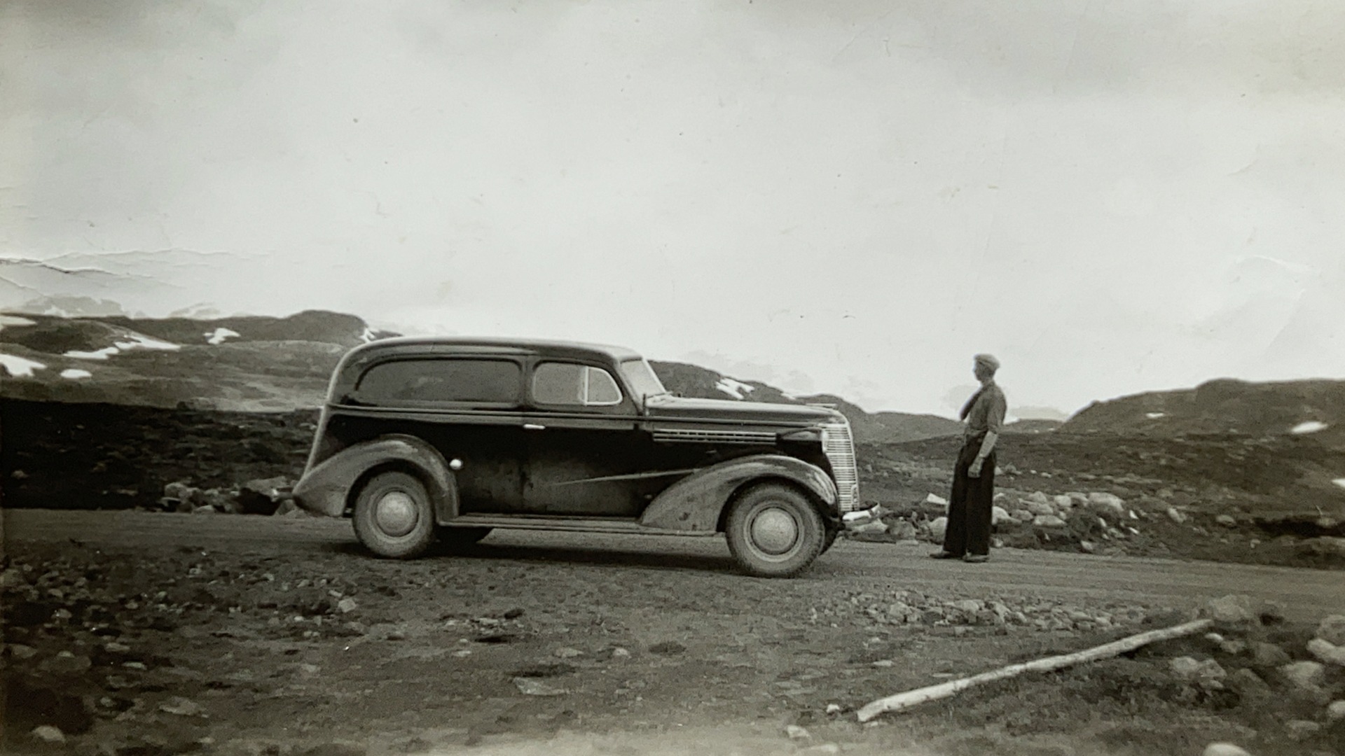 Emanuel Jørgensen og hans 1938 Chevrolet Delivery. Jørgensen var ikke redd for å ta med bilen på fjelltur. Her nyter han utsikten, mens Deliveryen får en pust i bakken. 