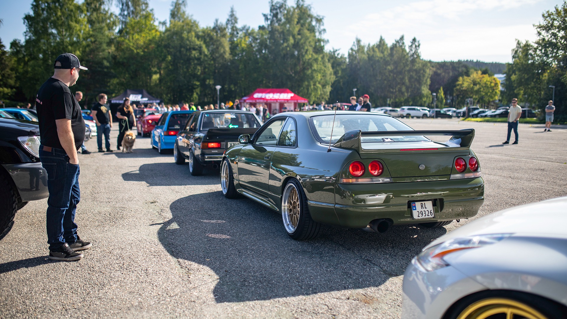 Det stirres og lyttes i det bilene begynner å strømme til, her med en Skyline R33 i fokus.