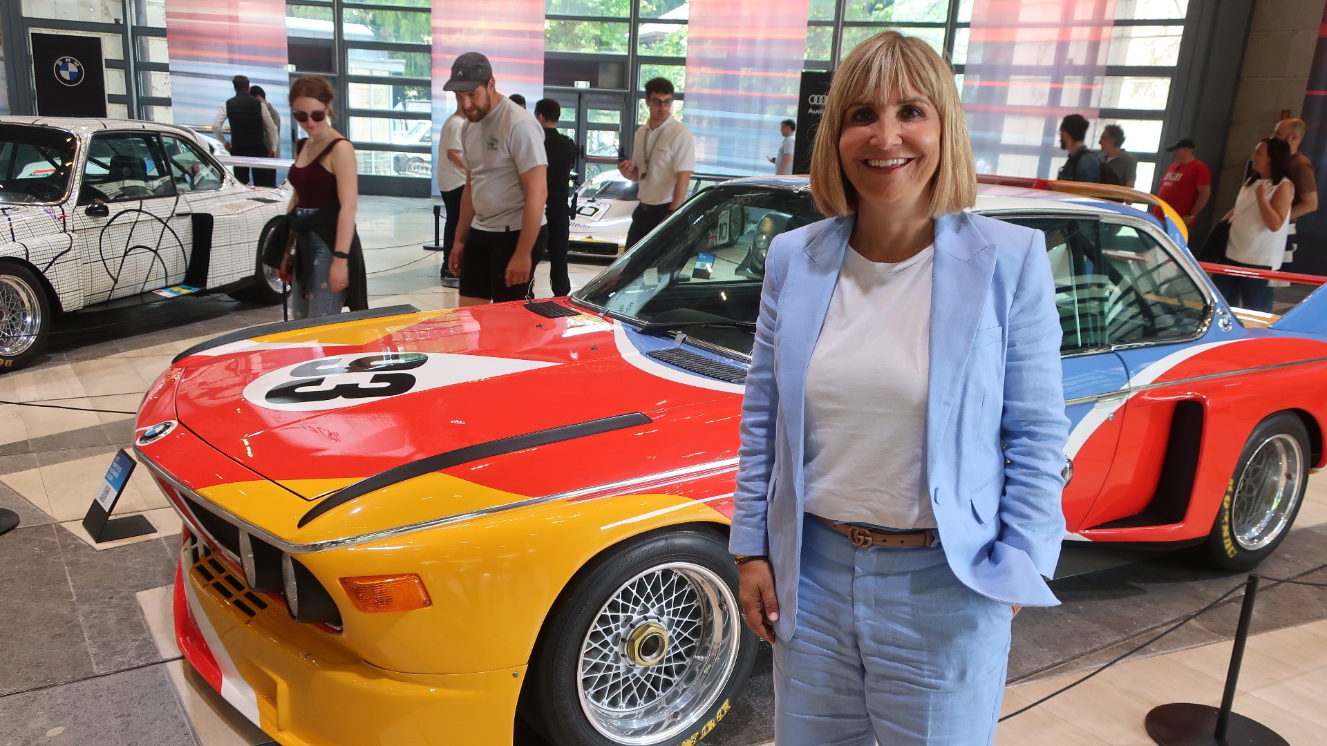 En blid og fornøyd Silke Brigl foran en av BMWs Art Cars som hadde en egen utstliling på Villa Erba.