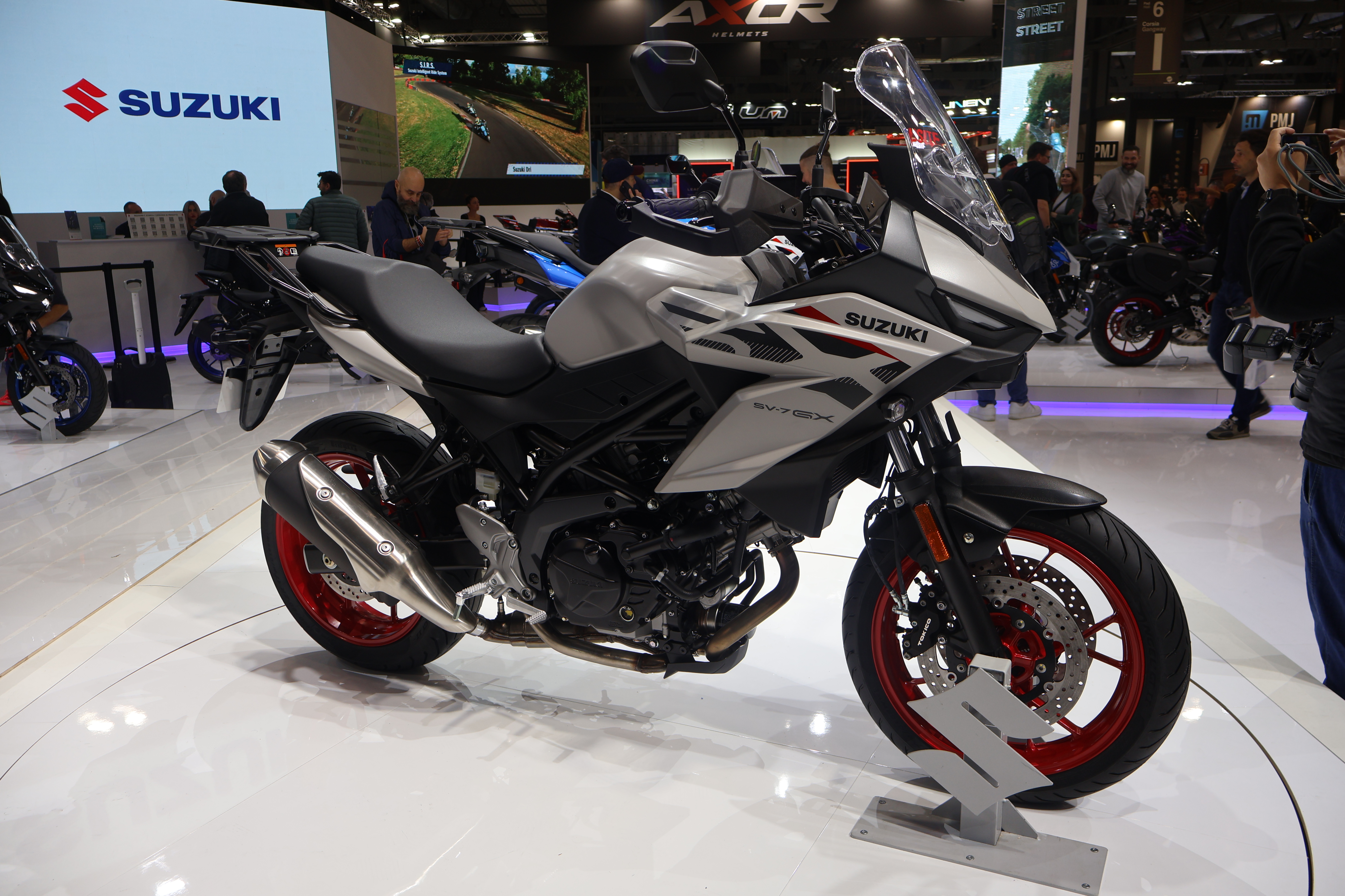 Suzuki SV-7GX. Mange har et godt forhold til Suzuki SV650 som var en populær modell, og da er det godt nytt for mange at V-twin plattformen vil leve videre i den nye SV-7GX. Her får du den slitesterke 645 kubikks V-Twin motoren på 73 hk v/8500 (over 500.000 sykler har blitt bygget av Suzuki med versjoner av denne motoren siden 1999), og her får du også «Low RPM Assist» som øker turtallet litt når du drar avgårde fra f.eks et lyskryss for å hindre at du kveler sykkelen. LED-lys er på plass, og en 4,2 toms TFT skjerm gir mange ulike layouts. Vindskjermen er tre-veis justerbar, og en nydesignet 17,4 liters bensintank på plass. Med en salhøyde på 795 mm (setet har fått tykkere innlegg for bedre komfort) kombinert med smale proporsjoner takket være V-Twin motoren, vil sykkelen passe et rikt utvalg av førere ifølge Suzuki. Styret er nå 24 mm nærmere føreren enn på den nakne SV, og 17 mm høyere, noe som skal gi en mer avlslappet førerposisjon på lange turer. Vekten er 211 kg og sykkelen kommer i tre ulike farger, mens dekkene er Pirelli Angel GT II.   