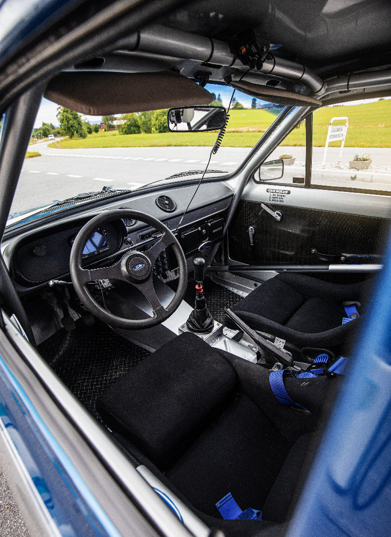 Du klatrer inn i en rallybil på hvite skilter