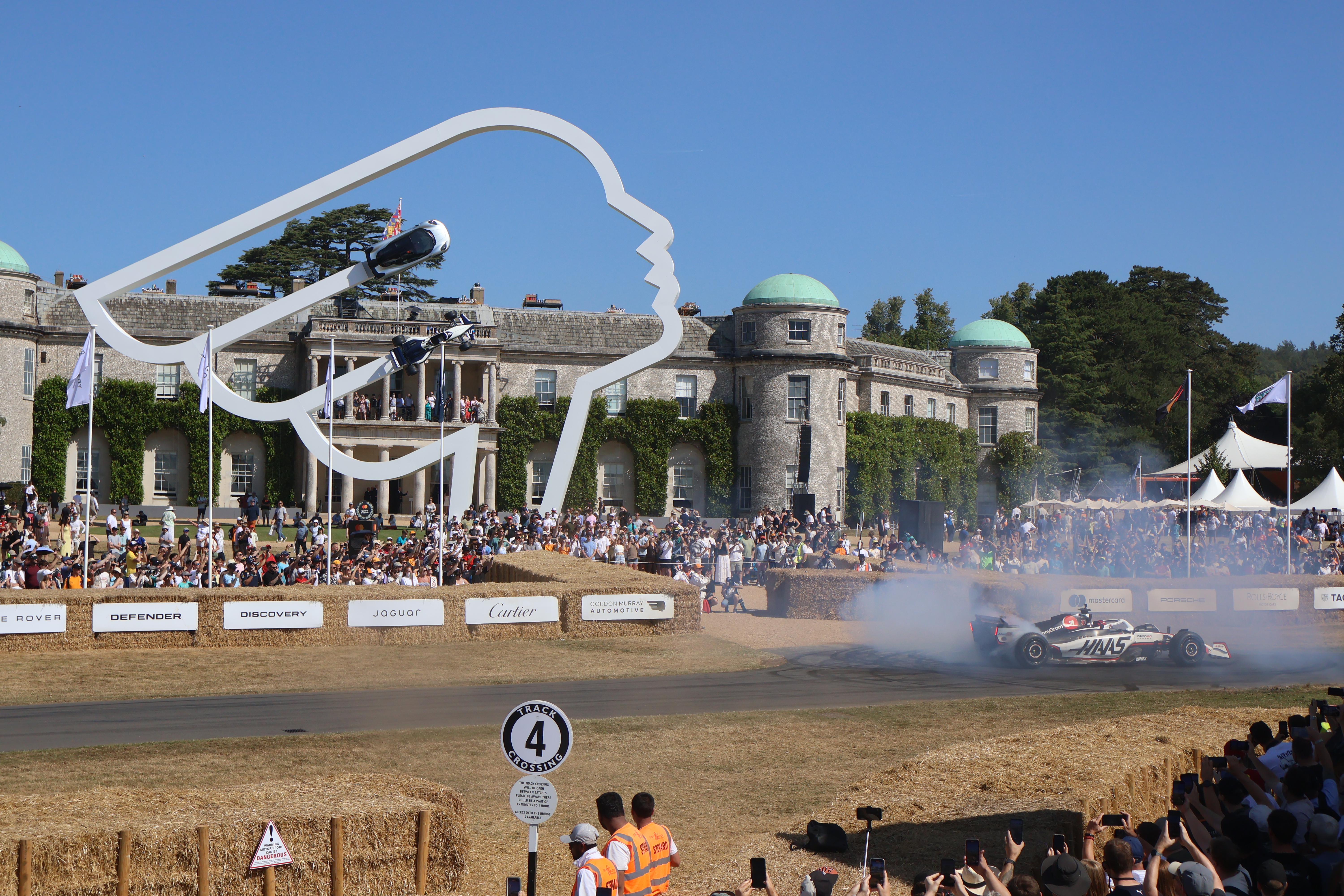 Årets skulptur foran Goodwood House hedret Gordon Murray, her med en Haas F1 bil i aksjon på vei opp bakken. 
