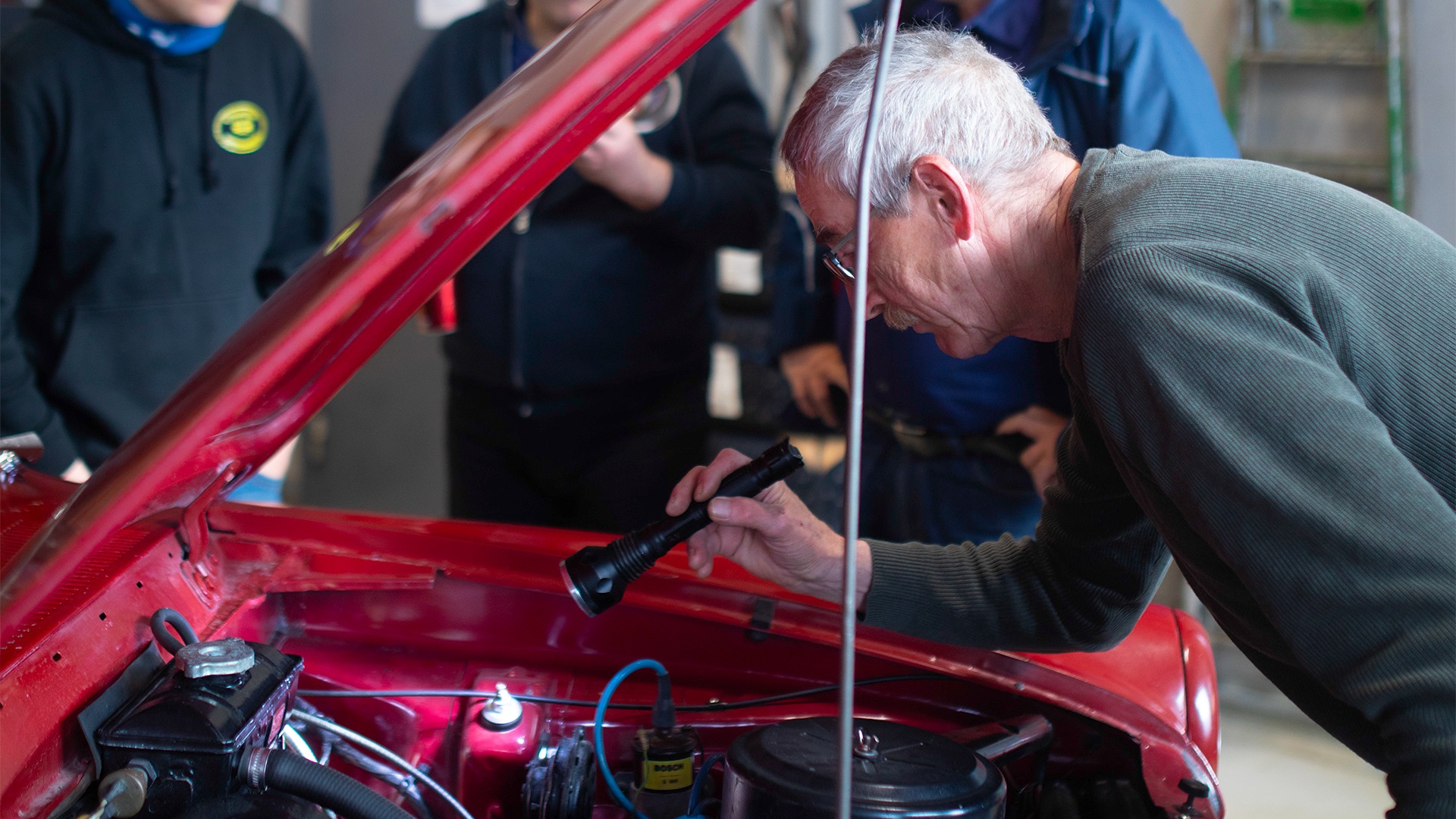 Rolf Nordli med fokuset godt plassert nedi panseret på en Ford Taunus 12M